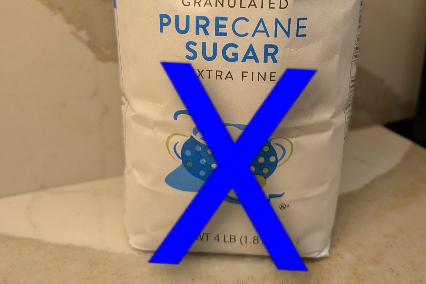 A bag of granulated sugar with a large X drawn through it